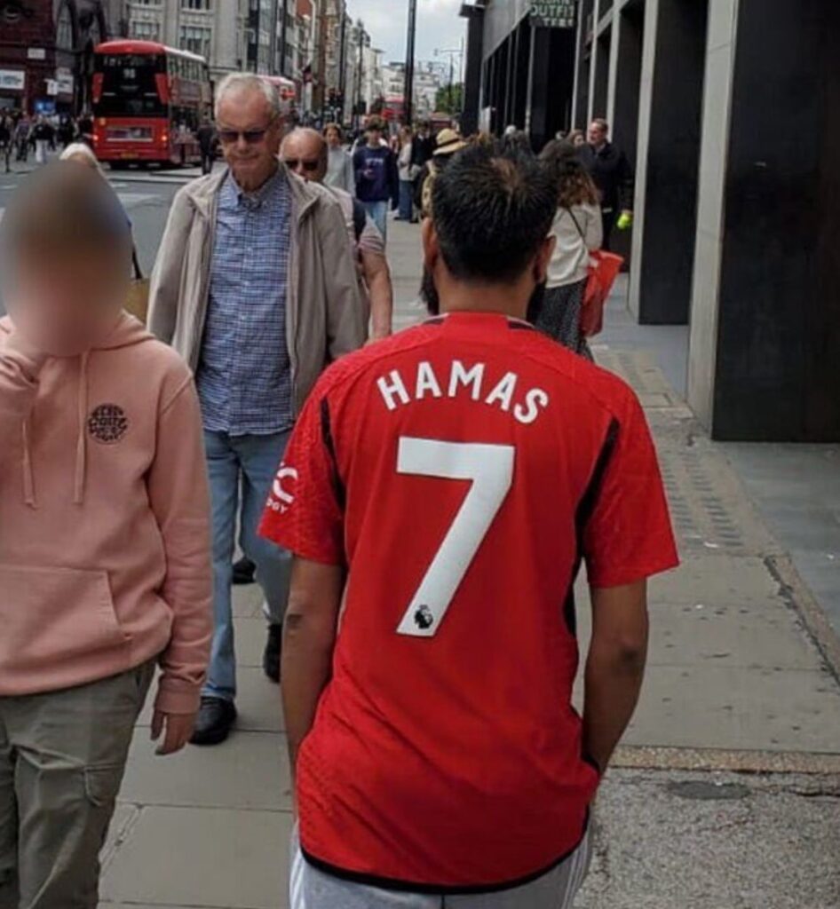 [בתמונה: אדם הולך ברחוב אוקספורד בלונדון לבוש בחולצת טריקו 'חמאס 7', המתייחס לפיגוע ב-7 באוקטובר. המקור: דף הטוויטר של Oli London. אנו מאמינים כי אנו עושים בתמונה שימוש הוגן]